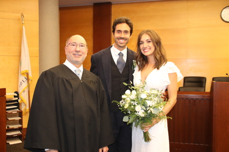 Judge William Engerman poses with couple after performing their wedding ceremony