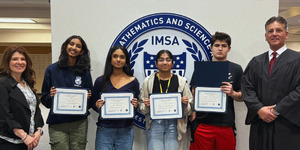 Illinois Math and Science Academy Law Day Essay Contest winners (center) with Kane County Bar Foundation Executive Director Ann Lobb (left) and Chief Judge Robert Villa (right) presenting the awards at their high school.